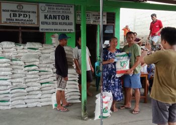 Pemdes Hilifalago Menyalurkan Bantuan Pangan Kepada 164 KPM Di Balai Desa.